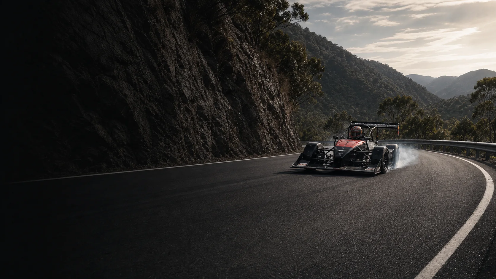 Competition car producing tyre smoke on sealed bitumen